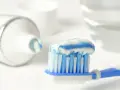 Szczoteczka z pastą do zębów, która zawiera fluor, gotowa do porannego mycia.