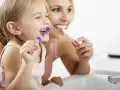 Mama uczy córkę myć zęby. Nie chcemy, by dzieci które nie myją zębów miały próchnicę!