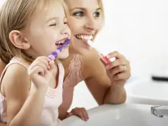 Mama uczy córkę myć zęby. Nie chcemy, by dzieci które nie myją zębów miały próchnicę!