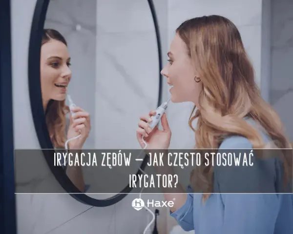 Kobieta używa irygatora do zębów przed lustrem. Dowiedz się, jak często stosować irygator dla zdrowego uśmiechu.