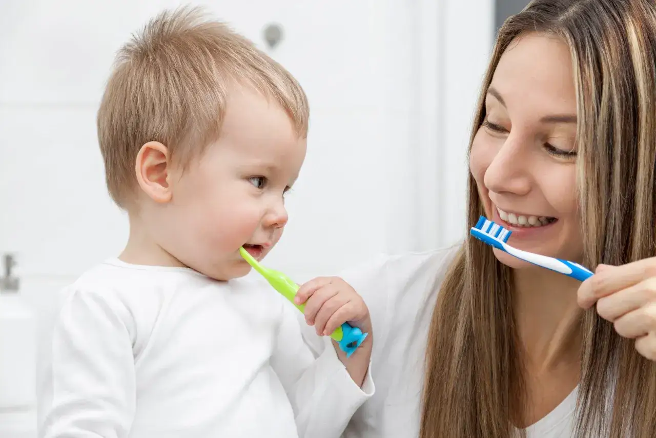 Mama uczy malucha myć zęby. Dzieci kt&oacute;re nie myją zęb&oacute;w szybko się psują, dlatego warto dbać o higienę od najmłodszych lat.