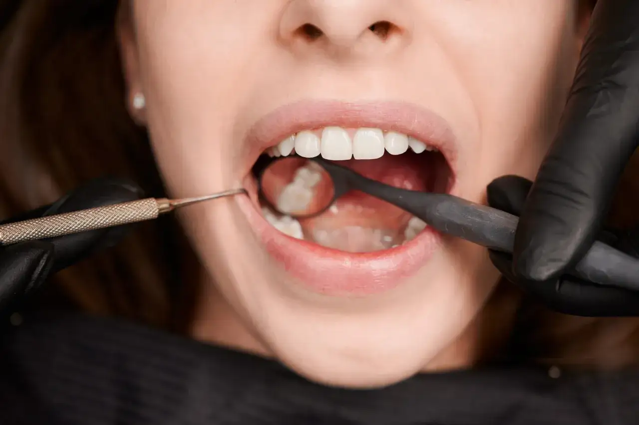 Dentysta bada zęby, gdy pacjent odczuwa ból dziąsła na końcu szczęki.